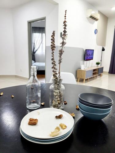 a black table with a plate and a vase at Residensi Flora in Seri Kembangan