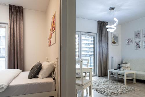 a bedroom with a bed and a dining room at Wola Glamour Apartment in Warsaw