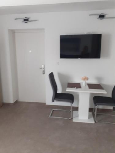 Apartments Stars في فيليكا غوريكا: غرفة مع طاولة وكراسي وتلفزيون