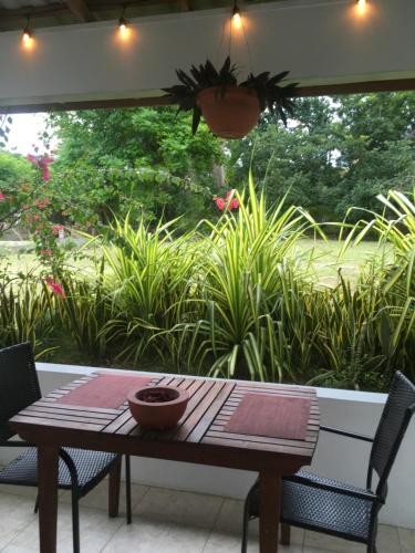 a wooden table with a bowl on it on a patio at Ancella's Garden Apartment-Beach-5min Drive, 1 hr Montego Bay, 25 mins Ocho Rios, Continental Breakfast in Runaway Bay