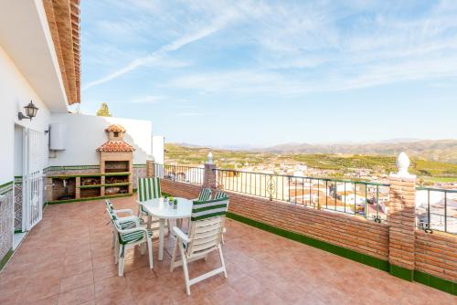 a patio with a table and chairs on a balcony at Villa Cañete in Benamocarra