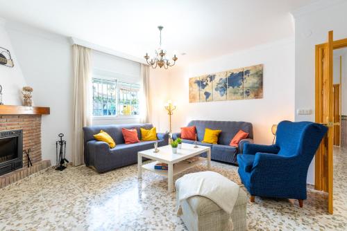 a living room with blue couches and a fireplace at Villa Cañete in Benamocarra
