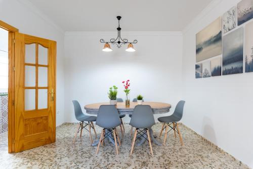 a dining room with a table and blue chairs at Villa Cañete in Benamocarra