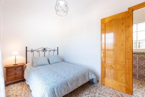 a bedroom with a bed and a wooden door at Villa Cañete in Benamocarra