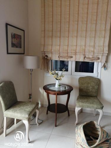 a living room with a table and two chairs and a window at Villa Myrto in Kyparissia
