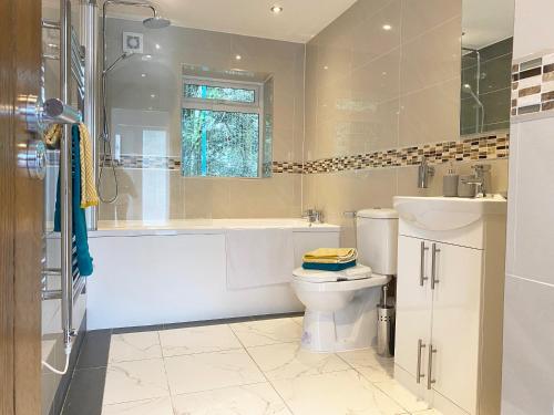 a bathroom with a tub and a toilet and a sink at 2 Bedroom Holiday Home near Bolton, Appleby-in-Westmorland in Kirkby Thore