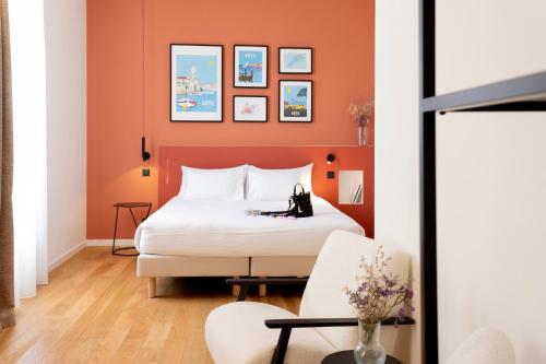a bedroom with a bed with orange walls at Les Clés Secrètes in Sète