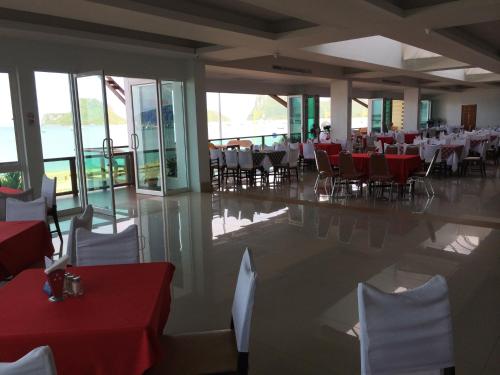 a restaurant with red and white tables and chairs at Hadthong Hotel in Prachuap Khiri Khan