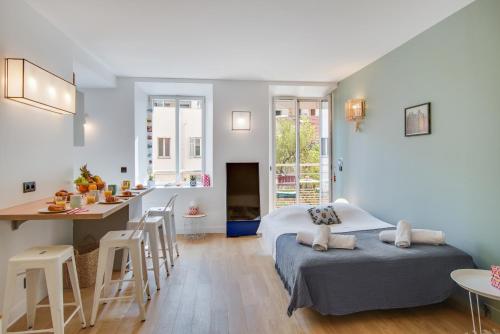 Cette chambre comprend deux lits, une cuisine et une table. dans l'établissement Gold Apartment, à Cannes