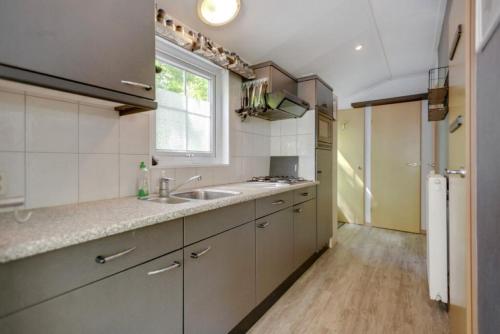 a kitchen with a sink and a window at Boshuisje- Chez Michel in Wageningen