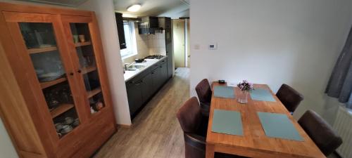 a kitchen with a table and chairs and a kitchen with a counter at Boshuisje- Chez Michel in Wageningen