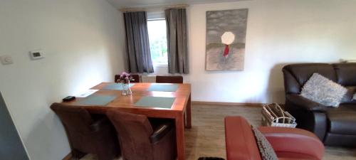 a living room with a wooden table and chairs at Boshuisje- Chez Michel in Wageningen