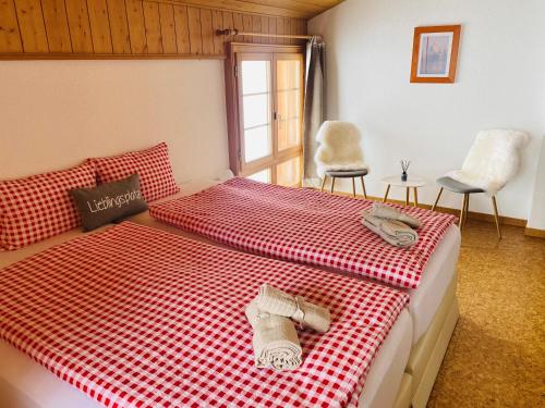 - une chambre dotée d'un lit avec une couverture rouge et blanche en damier dans l'établissement Chalet Sepp, à Belalp