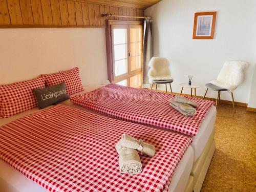 a bedroom with a bed with a red and white checkered blanket at Chalet Sepp in Belalp