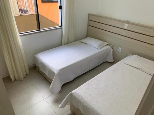 Habitación pequeña con cama y ventana en Res. Estoril, en Bombinhas