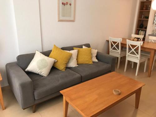 sala de estar con sofá gris y almohadas amarillas en Condado de Alhama PH1502, en Alhama de Murcia