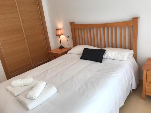 Un dormitorio con una cama blanca con toallas. en Condado de Alhama PH1502, en Alhama de Murcia