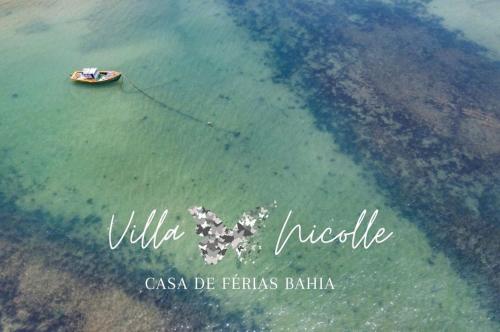 a boat in the water near the shore at Villa Nicolle - Bahia - Praia do Espelho in Praia do Espelho