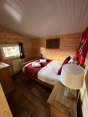 a bedroom with a bed in a wooden cabin at Gulliver's Valley, M1, JCT 31 in Rotherham