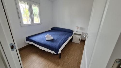 a small bedroom with a bed with a hat on it at Sabiñanigo Camp & Hotel in Sabiñánigo