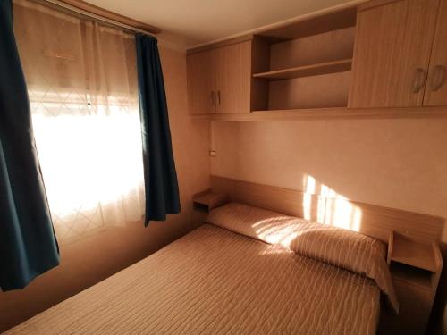 a small bedroom with a bed and a window at Tobacco Road camping Sirolo in Sirolo