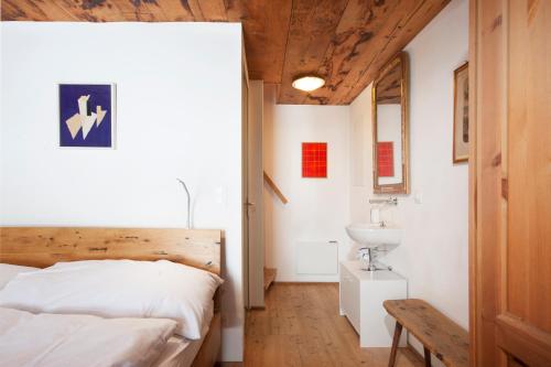 a bedroom with a bed and a sink at Denkmalgeschützter Spycher total renoviert in Niederwald