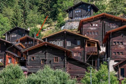 a group of wooden buildings with a building on a hill at Denkmalgeschützter Spycher total renoviert in Niederwald