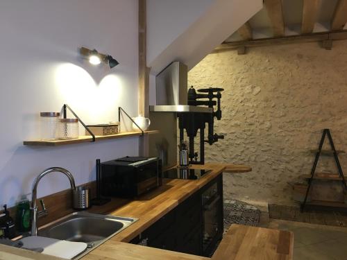 a kitchen with a sink and a microwave at Les gîtes du Val de Chambord in Huisseau-sur-Cosson