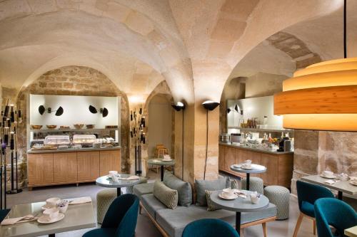 a restaurant with aamed ceilings and tables and chairs at Millésime Hôtel in Paris