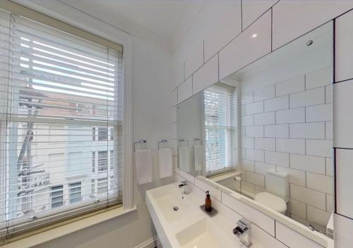 布萊頓霍夫的住宿－Hotel Nineteen，白色的浴室设有水槽和镜子
