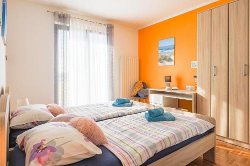 2 camas en un dormitorio con paredes de color naranja en Villa Leona, en Čabrunići