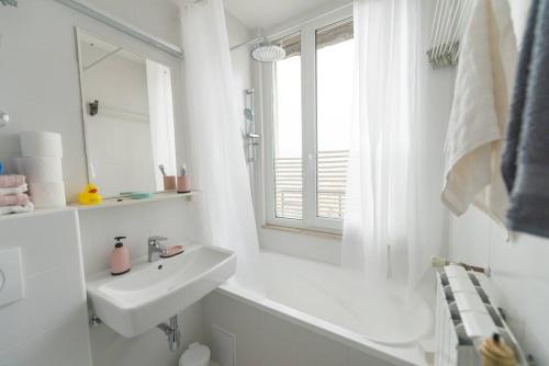 ein weißes Badezimmer mit einem Waschbecken und einem Spiegel in der Unterkunft UNIT4SIX in Sarajevo