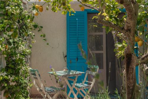a table and chairs in front of a blue door at La Casa del Limoneto in Favignana