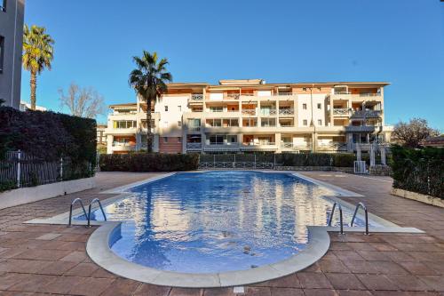 une grande piscine devant un immeuble dans l'établissement Le Cyana, à Cagnes-sur-Mer