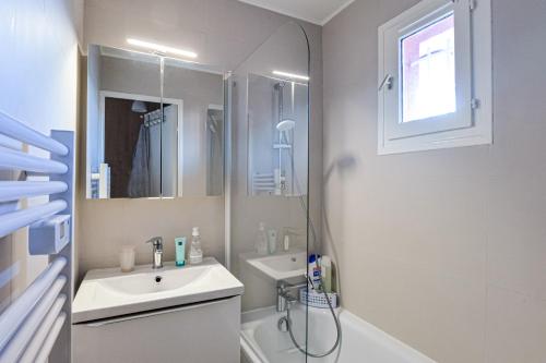 une salle de bain blanche avec un lavabo et une douche dans l'établissement Le Cyana, à Cagnes-sur-Mer