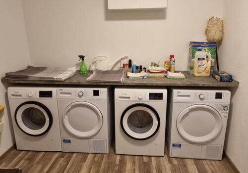 uma lavandaria com duas máquinas de lavar roupa e um balcão em Gästezimmer Sarstedt em Sarstedt