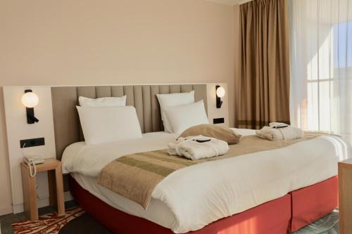 a bedroom with a large bed with two towels at Mercure Amiens Cathédrale in Amiens
