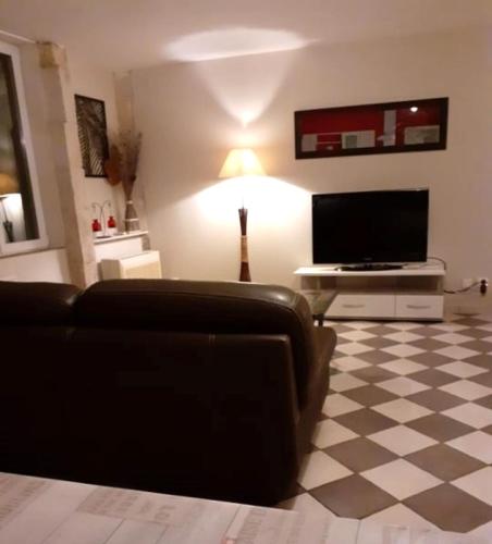 a living room with a couch and a flat screen tv at Studio meublé 50m2 - Entrée indépendante in Demange-aux-Eaux