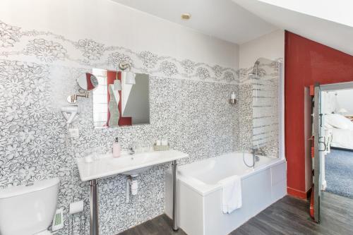 a bathroom with a sink and a toilet and a tub at La Maison D'Hôtes Nantes Centre in Nantes