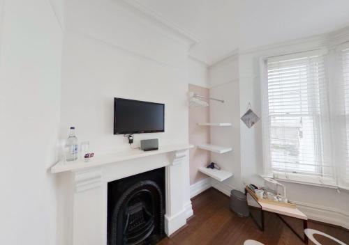 a living room with a fireplace with a flat screen tv at Hotel Nineteen in Brighton & Hove
