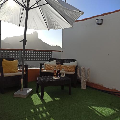 a patio with a table and an umbrella at Casa Ada in Tejeda