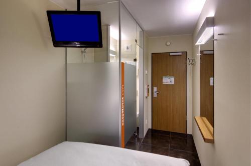 a room with a bed and a tv on a wall at easyHotel Berlin Hackescher Markt in Berlin