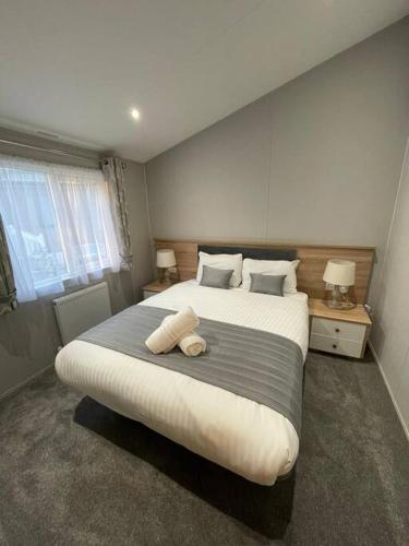 a bedroom with a large bed with two pillows at Beryl Lodge with Hot Tub in York