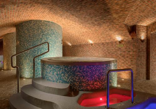 a hot tub in a room with a brick wall at Hotel Gino Park Palace - Kaštieľ Orlové in Považská Bystrica