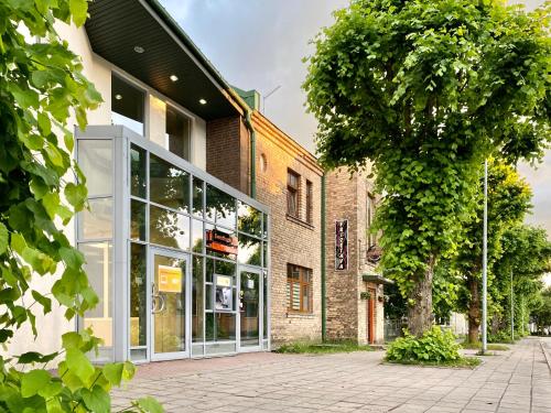 a building with large glass windows and a tree at Cesis Boulevard Apartments in Cēsis