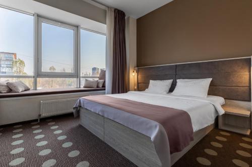 a bedroom with a large bed and a large window at Ambassador Plaza in Kyiv