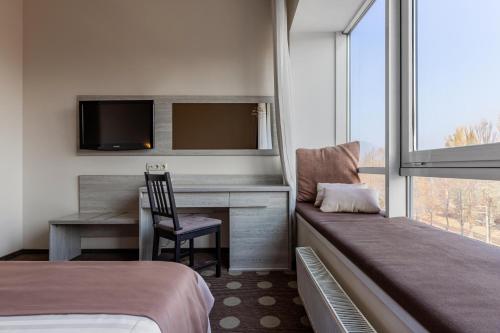 a hotel room with a desk and a chair at Ambassador Plaza in Kyiv