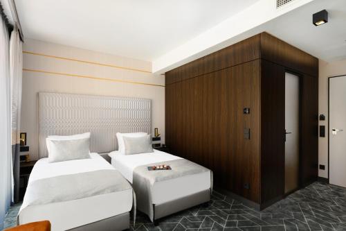 a bedroom with two beds and a cabinet at Emerald Hotel by Continental Group in Budapest