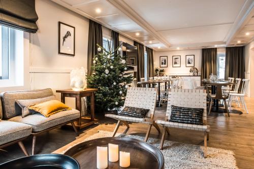 - un salon avec un arbre de Noël et des chaises dans l'établissement Chalet hôtel le Whymper, à Chamonix-Mont-Blanc