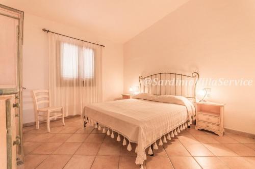 una camera da letto con un letto, una sedia e una finestra di Villa Cala Granu - Porto Cervo a Porto Cervo